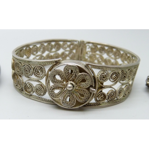 7079 - Four silver bangles, two white metal torque bangles and a filigree bangle, 86g