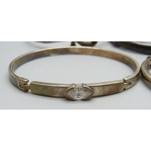 7079 - Four silver bangles, two white metal torque bangles and a filigree bangle, 86g