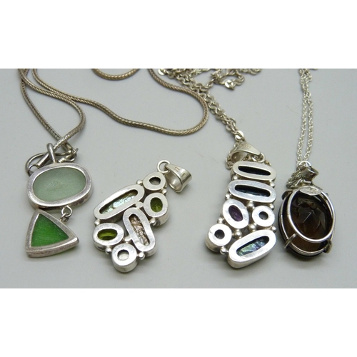 7092 - Four silver mounted pendants and three chains