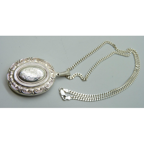 7094 - A silver locket and chain, 36g, chain 50cm