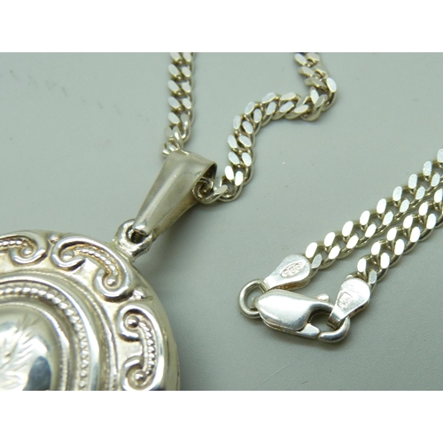 7094 - A silver locket and chain, 36g, chain 50cm