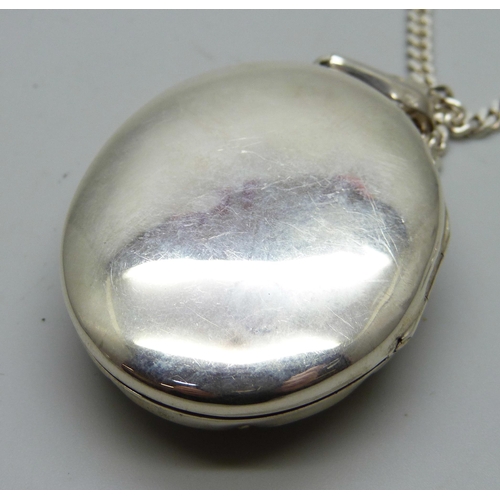 7094 - A silver locket and chain, 36g, chain 50cm