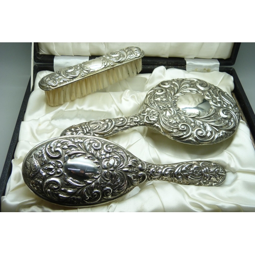 7277 - An embossed silver vanity set in a fitted case