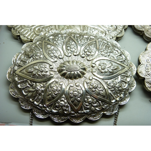 7284 - Four medium and small embossed white metal wall mirrors, (medium 15cm x 20cm)