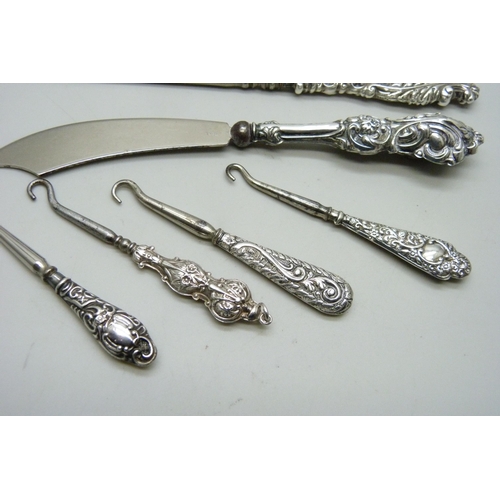 7285 - Silver handled button hooks and a paper knife