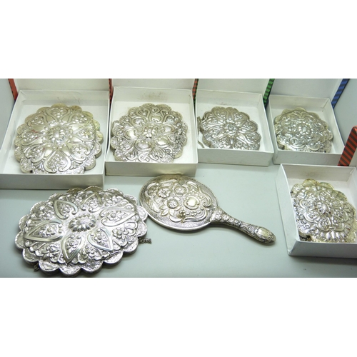 7297 - Five boxed embossed white metal wall mirrors and two others