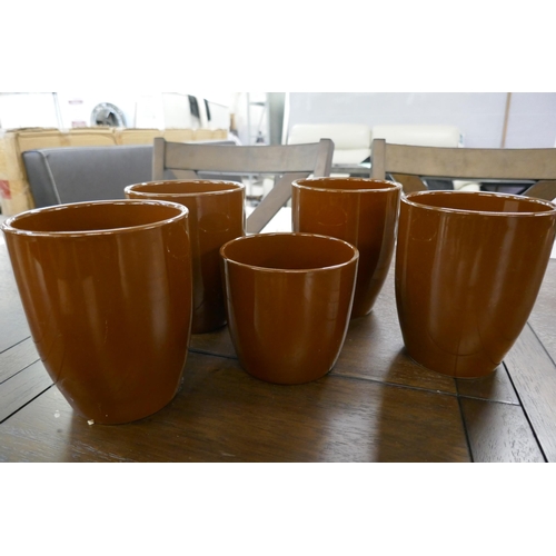 3108 - A set of five caramel painted plant pots in assorted sizes