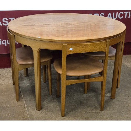 20 - A Nathan teak circular extending dining table and four chairs