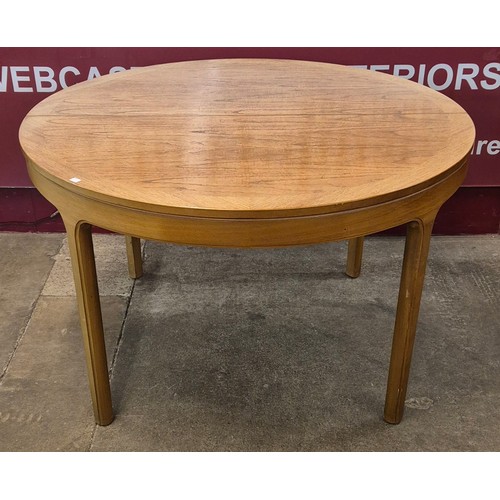 20 - A Nathan teak circular extending dining table and four chairs