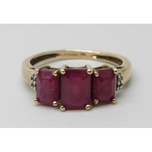 7001 - A 9ct gold three stone ruby ring set with diamonds, 2.4g, O