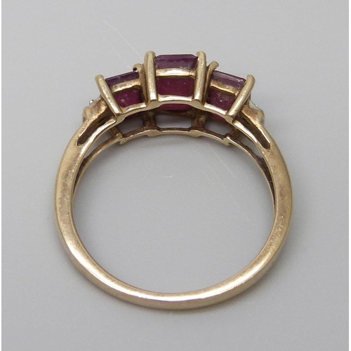 7001 - A 9ct gold three stone ruby ring set with diamonds, 2.4g, O