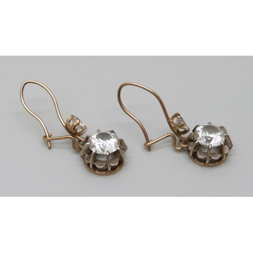 7002 - A pair of yellow metal drop earrings set with white stones, 1.9g