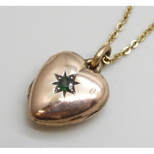 7045 - A c1900 9ct gold locket set with a green stone and on a chain, locket 3.5g