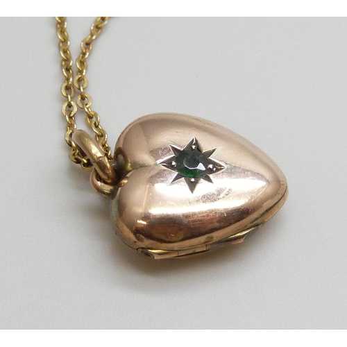 7045 - A c1900 9ct gold locket set with a green stone and on a chain, locket 3.5g