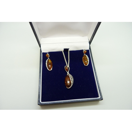 7125 - A silver and amber pendant and earrings