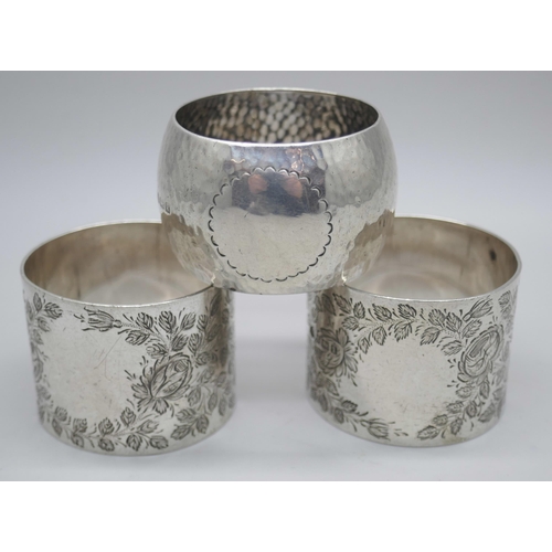 7351 - A pair of silver napkin rings, Birmingham 1910, and a hammered silver napkin ring, Birmingham 1909, ... 