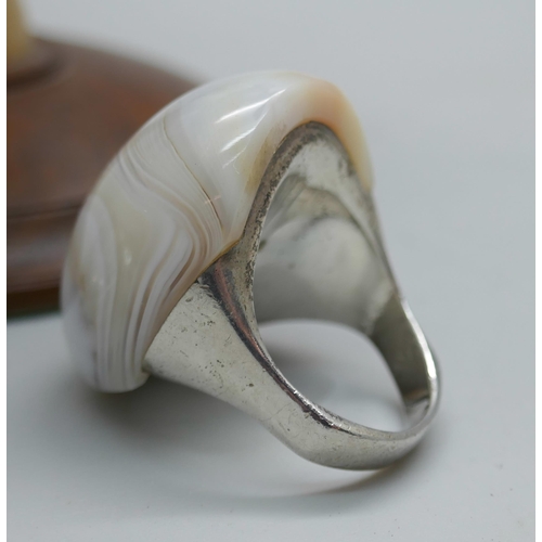 7355 - A wooden stand with silver earrings, a Scottish silver napkin ring and two silver rings, both size N