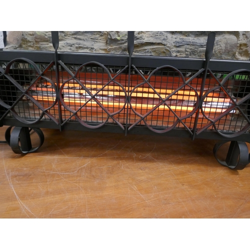 5101 - A log effect electric fire with a cast iron effect surround