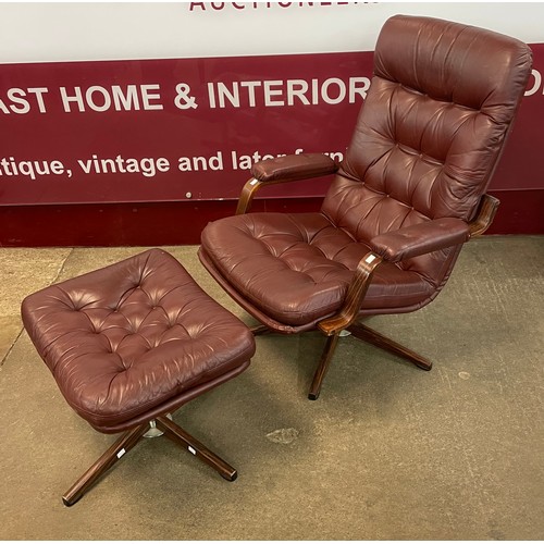 85 - A chrome, simulated rosewood and burgundy leather revolving lounge chair and footstool