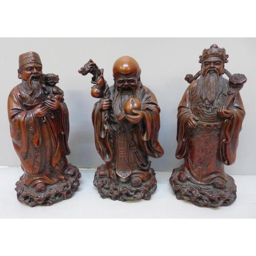 2067 - A set of three boxed Chinese cinnabar resin Immortals