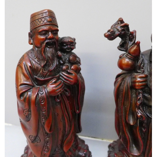 2067 - A set of three boxed Chinese cinnabar resin Immortals