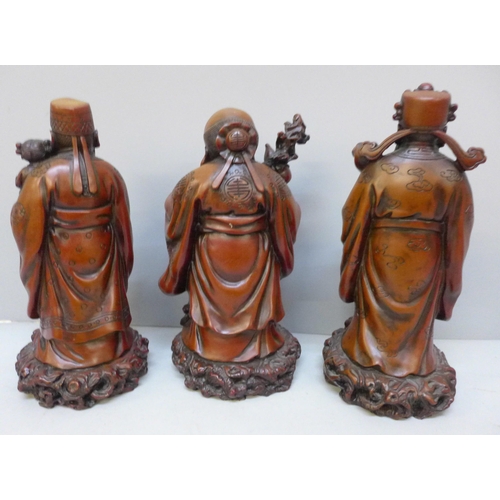 2067 - A set of three boxed Chinese cinnabar resin Immortals