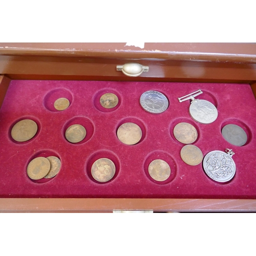 2311 - A collectors cabinet with coins and a WWII medal