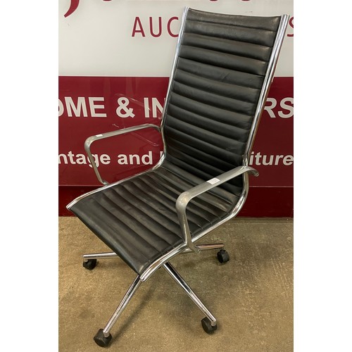 83C - An Eames style chrome and black leather revolving desk chair