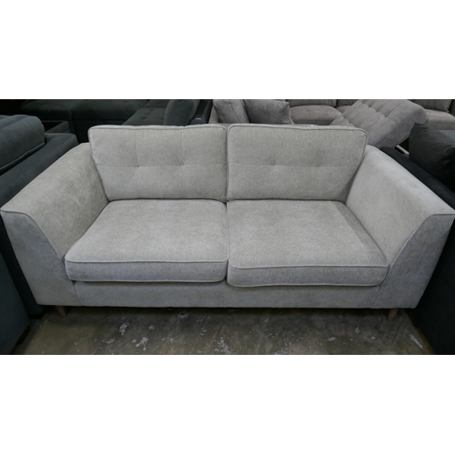 3030 - An oatmeal fabric upholstered three seater sofa and armchair (mixed feet)