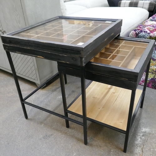 3214 - A black painted pine glass topped collectors cabinet nest of tables