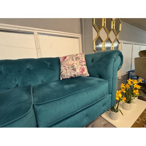 3025 - A turquoise velvet upholstered Chesterfield three seater sofa with patterned scatter cushions on tur... 