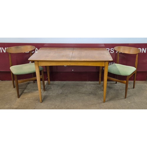 23 - A teak rectangular extending dining table and two chairs