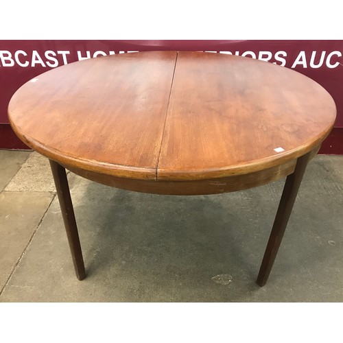 64 - A teak circular extending dining table