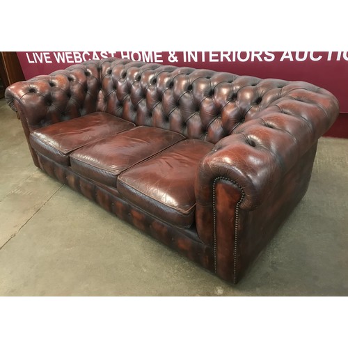 76 - A chestnut brown leather three seater Chesterfield settee