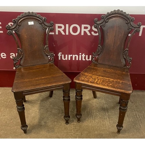 86 - A pair of Victorian carved oak hall chairs