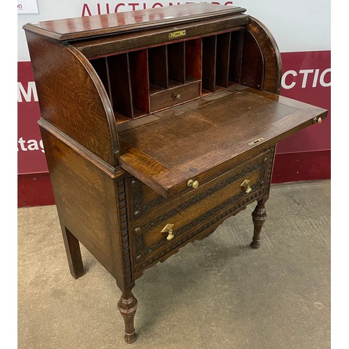 107 - An early 20th Century Jacobean Revival carved oak cylinder bureau