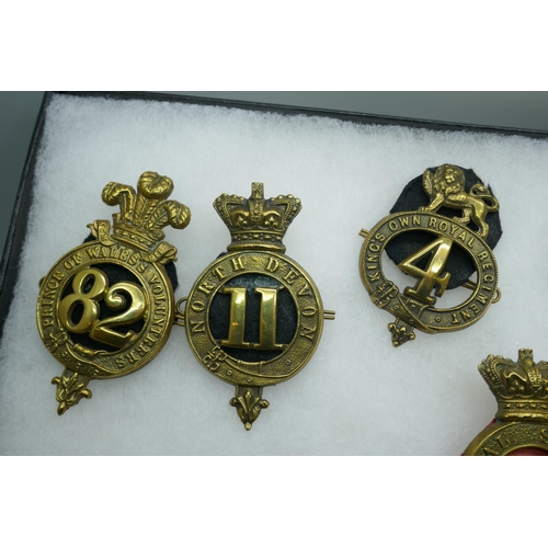 2206 - A collection of military regimental badges, mainly 19th century, also a buckle