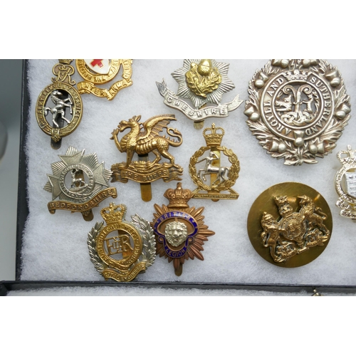 2219 - A collection of military regimental cap badges