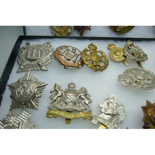 2219 - A collection of military regimental cap badges