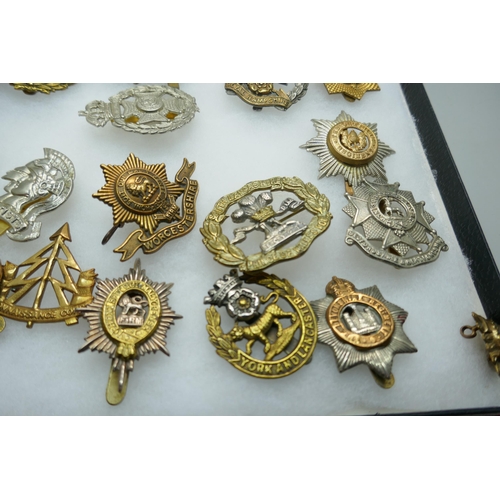 2219 - A collection of military regimental cap badges