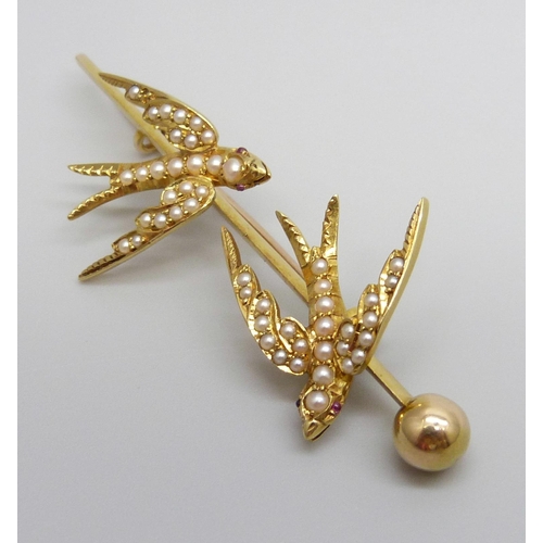 7001 - A 15ct gold brooch depicting two swallows set with seed pearls and with ruby eyes, 7.1g, 57mm