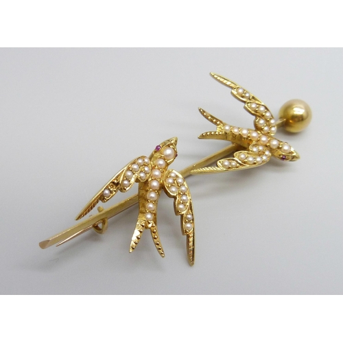 7001 - A 15ct gold brooch depicting two swallows set with seed pearls and with ruby eyes, 7.1g, 57mm