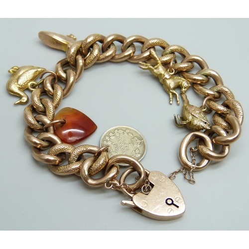 7033 - A 9ct gold curb chain bracelet with six charms, 4 gold, an agate heart and a silver 1906 Canadian 5 ... 