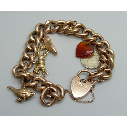 7033 - A 9ct gold curb chain bracelet with six charms, 4 gold, an agate heart and a silver 1906 Canadian 5 ... 