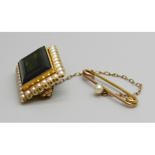 7034 - A 15ct gold brooch set with a green stone and a seed pearl border with a 9ct gold safety pin set wit... 