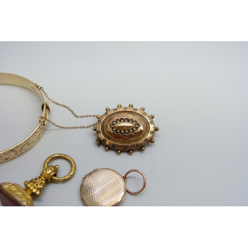 7037 - A 9ct gold metal core bangle, a gilt metal fob, a yellow metal memorial brooch and a yellow metal lo... 