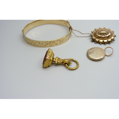 7037 - A 9ct gold metal core bangle, a gilt metal fob, a yellow metal memorial brooch and a yellow metal lo... 