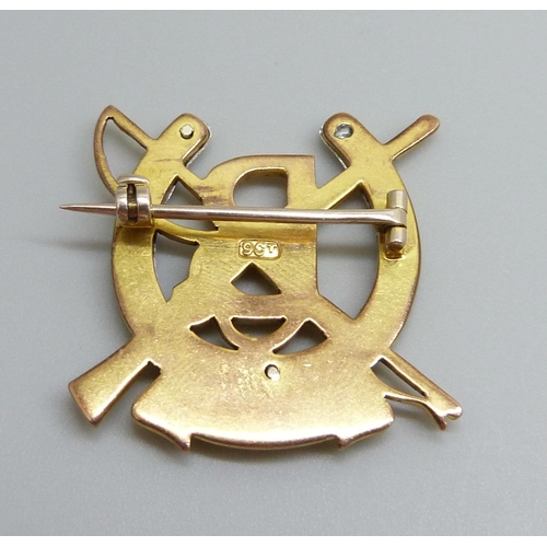 7040 - A 9ct gold military brooch with rifle and riding crop detail and the letter 'B' in a horseshoe and m... 