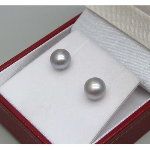 7042 - A pair of 9ct yellow gold mounted pearl stud earrings