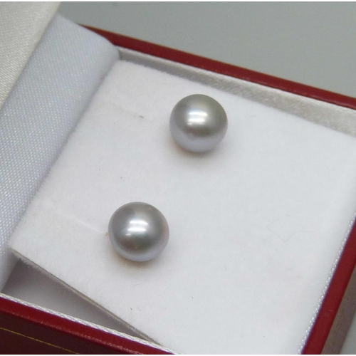 7042 - A pair of 9ct yellow gold mounted pearl stud earrings